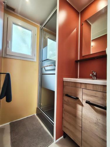 a small kitchen with a sink and a refrigerator at Camping Magali Plage in Liourdres