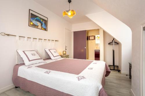 a bedroom with a large bed with pink and white sheets at Chez Coco in Trégunc