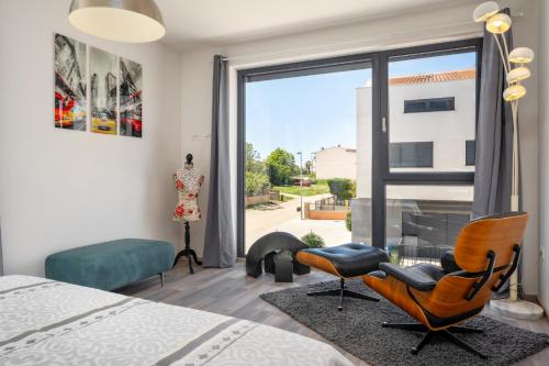 a bedroom with a bed and two chairs and a window at Casa Seal by Briskva in Funtana