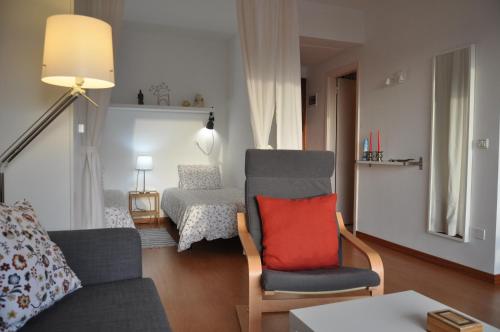 - un salon avec un canapé et une chaise avec un oreiller rouge dans l'établissement Apartment La Paz, à Puerto de la Cruz