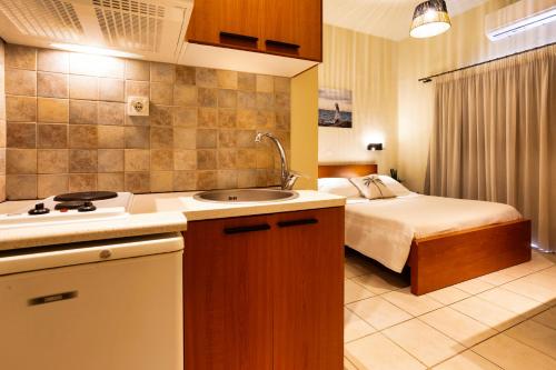 a kitchen with a sink and a bed in a room at Skinos Apartments in Plakias