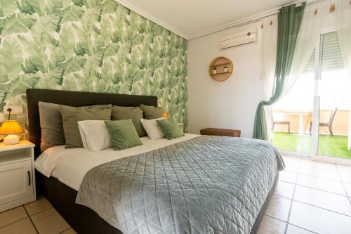 a bedroom with a bed with a green patterned wall at Hotel Costa Blanca Rojales in Rojales