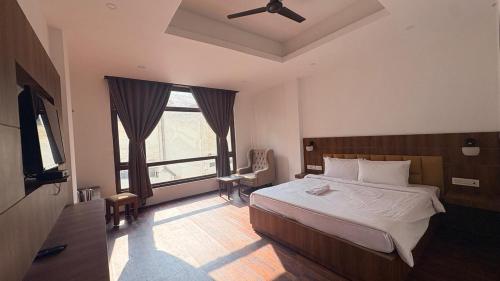 ein Schlafzimmer mit einem Bett und einem großen Fenster in der Unterkunft Hotel B Wings in Tādong