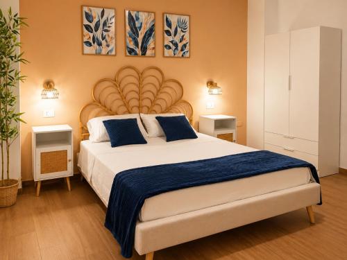 a bedroom with a large bed with blue pillows at Almarea Apartments in Santa Domenica