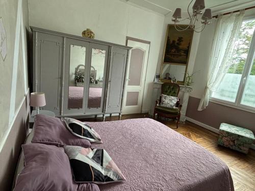 a bedroom with a large bed with a dresser at Le Chalet des Vignes in Saint-Laurent-des-Vignes