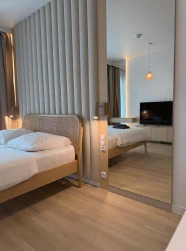 a hotel room with two beds and a television at Baltic Infinity Beach Spa in Międzyzdroje