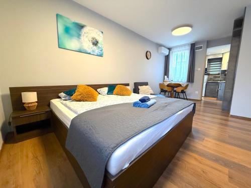 a bedroom with a large bed with yellow pillows at Paradiso Apartmanház in Gyula