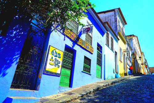 a blue and white building on a cobblestone street at Hostel Galeria 13 in Salvador