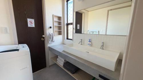 a bathroom with a sink and a large mirror at Villa Miura Beach -ヴィラ三浦海岸- in Miura