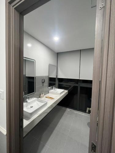 a bathroom with two sinks and two mirrors at Cozy Corner Beach Hotel in Phú Quốc