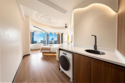 a bathroom with a sink and a bedroom with a bed at Chongqing Nanqing·World Time Hotel in Chongqing
