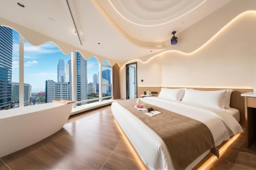 a bedroom with a large bed and large windows at Chongqing Nanqing·World Time Hotel in Chongqing