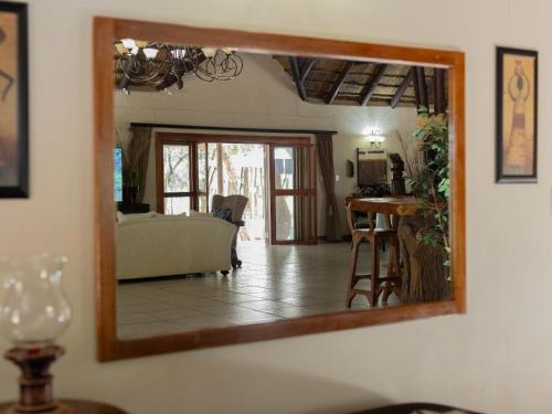 a mirror hanging on a wall in a living room at PHAKELA PRIVATE LODGE in Thabazimbi