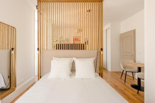 a bedroom with a white bed with white pillows at Downtown by Max, Refuge in city center in Mulhouse