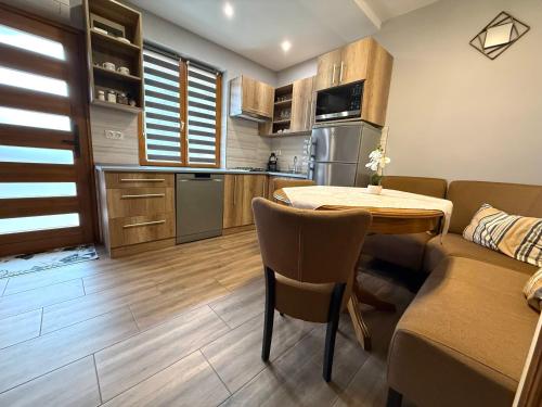 a kitchen and dining room with a table and a couch at Paradiso Apartmanház in Gyula
