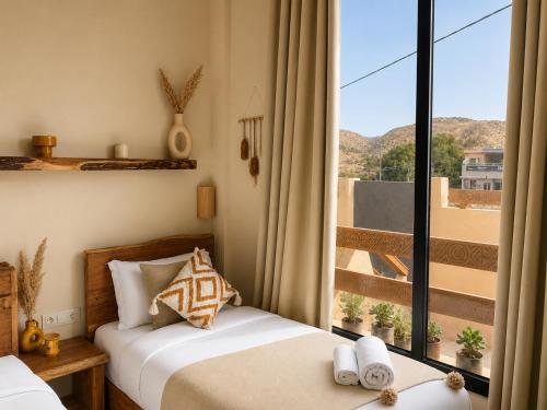 a bedroom with two beds and a large window at Arya Imsouane in Imsouane