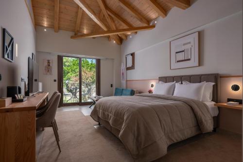 a bedroom with a large bed and a desk and a desk at Valeni Boutique Hotel & Spa in Portaria