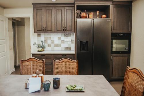a kitchen with a table and a refrigerator at River Mind Villa with SPA in Zalioji