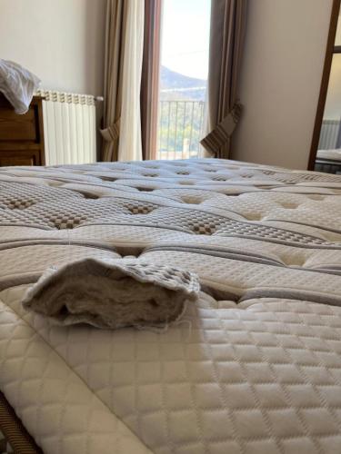 a white bed with a blanket on it with a window at Borgo Izzo 2 in San Fele