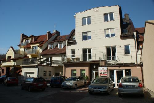 a group of cars parked in front of a building at Apartamenty Rok in Kołobrzeg