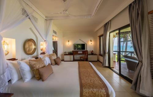 a bedroom with a large white bed in a room at Sea Cliff Resort & Spa in Zanzibar City