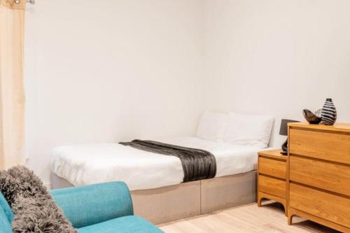 a bedroom with a bed and a dresser and a chair at Sleeps 2 - Central - Studio - WiFi - Paid Parking in Maidstone