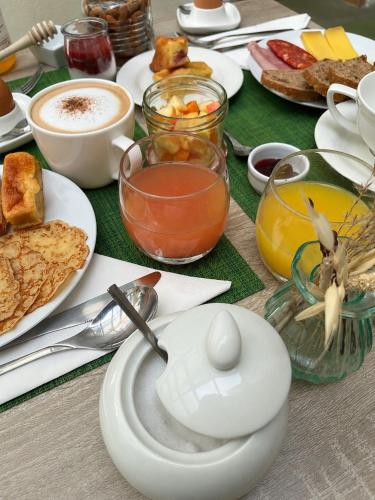a table with plates of food and cups of coffee at Hôtel D'Aragon - Place de la Comédie - in Montpellier