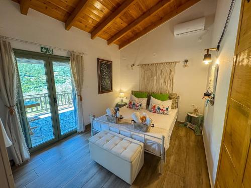 a room with a bed and a couch and a window at Elaia Rest House Retreat in nature in Fréngaina