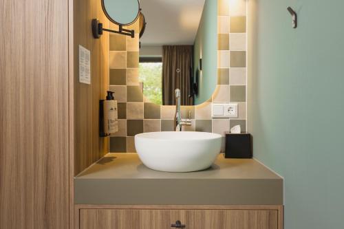a bathroom with a large white bowl sink on a counter at Hotel Riet I Kloeg Collection in Koudekerke