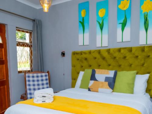 a bedroom with a bed with a yellow headboard at Zakumi Guesthouse in Kokstad