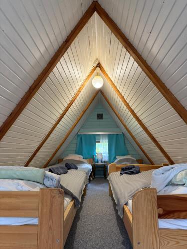 a group of four beds in a triangular room at Tleniowo Domek in Tleń
