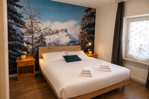 a bedroom with a bed with a snow covered wall at Erica in Folgaria