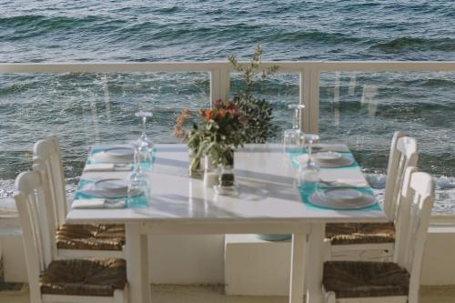 a white table with chairs and a view of the ocean at Villa Arancia Private Pool, 2 Jacuzzis & BBQ Area in Pigi