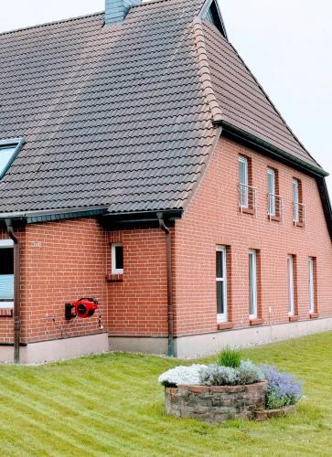 a red brick house with a black roof at FeWo Am Feldrand in Prebberede