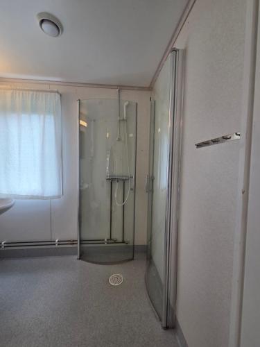 a bathroom with a shower and a glass door at Sonjas Camping & Stugor in Löttorp