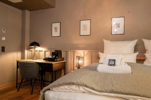 a bedroom with a bed and a desk at Wohnkultur - DSIGNIO Ladenburg Digital Hotel in Ladenburg