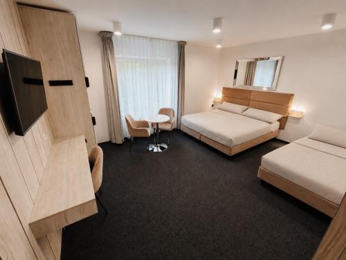 a hotel room with two beds and a television at Villa Viola in Mielno