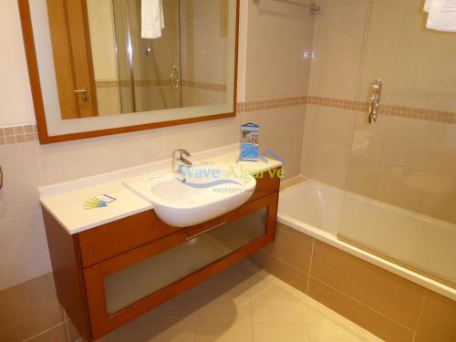 a bathroom with a sink and a shower and a mirror at O Pomar in Cabanas by Wave Algarve in Cabanas de Tavira