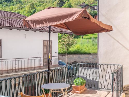 a patio table with an umbrella on a balcony at Rosano 76 in Cabella Ligure