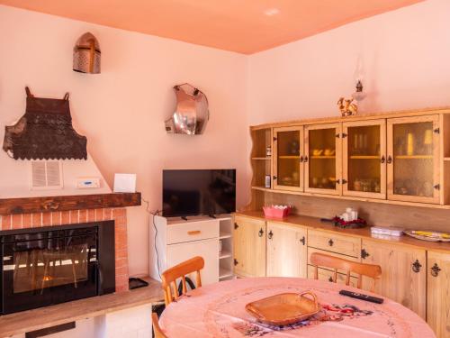 a kitchen with a table and a fireplace and a tv at Rosano 76 in Cabella Ligure