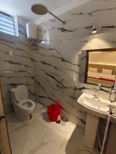 a bathroom with a toilet and a sink and a mirror at Sunview Resort in Mandarmoni
