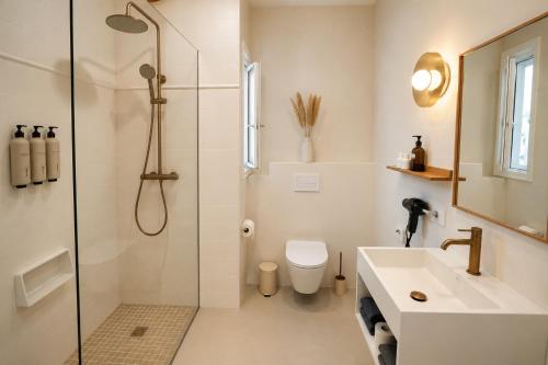 a bathroom with a shower and a toilet and a sink at Hotel S'Algaret in Fornells