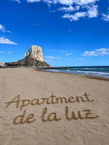 a sign written in the sand on a beach at Apartment-de-la-luz-calpe in Calpe