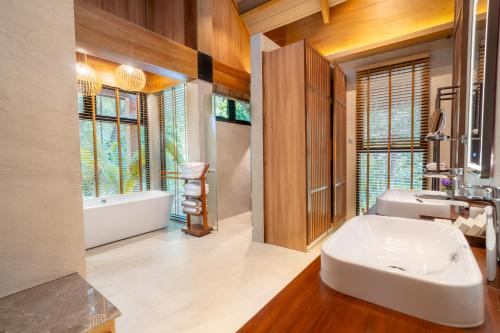 a bathroom with a large white sink and a tub at Ma'oni Seascape Villas in Panglao Island