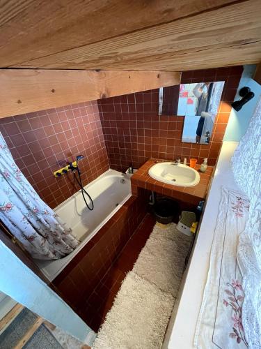 a small bathroom with a tub and a sink at Midi À La Place in Rians