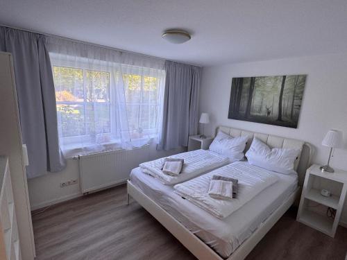 a bedroom with a white bed with two pillows on it at Heideglück in Visselhövede