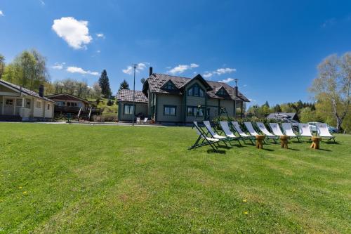a group of chairs sitting on a lawn in front of a house at Gorski park Kupjak in Kupjak