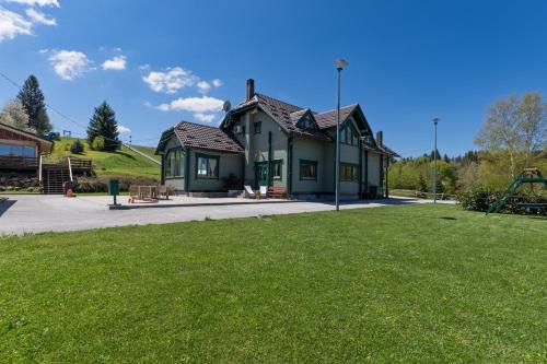 a house with a playground in front of a yard at Gorski park Kupjak in Kupjak