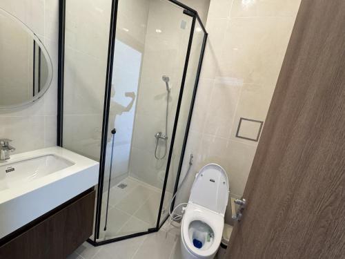 a bathroom with a toilet and a shower and a sink at Cuchi Downtown in Xóm Bến Cỏ