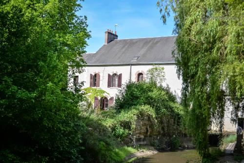 a white house with a river in front of it at Moulin XVe siècle - Gîte privatif 8 pers - Rivière - Châteaux de la Loire in Vineuil